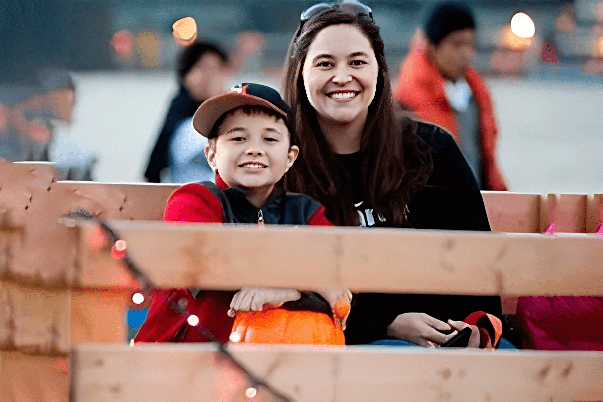 Smiling woman and child on a hayride.