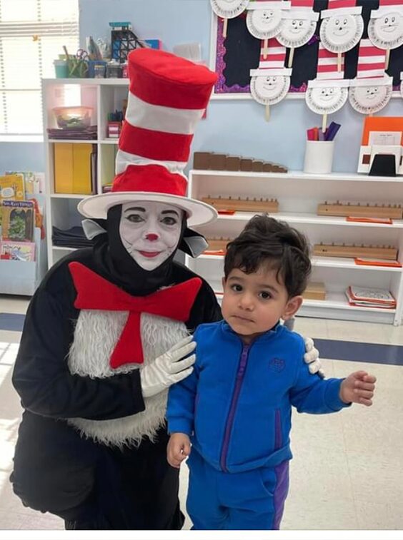 Person in costume with child at school.