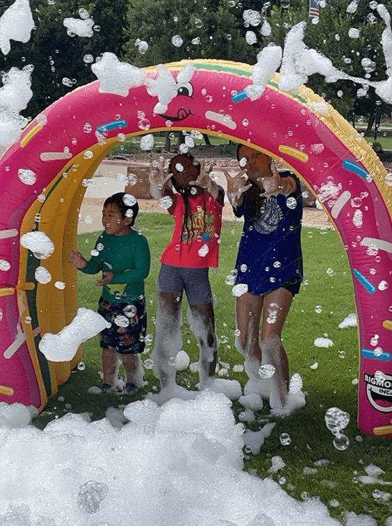 Kids playing in foamy inflatable structure.