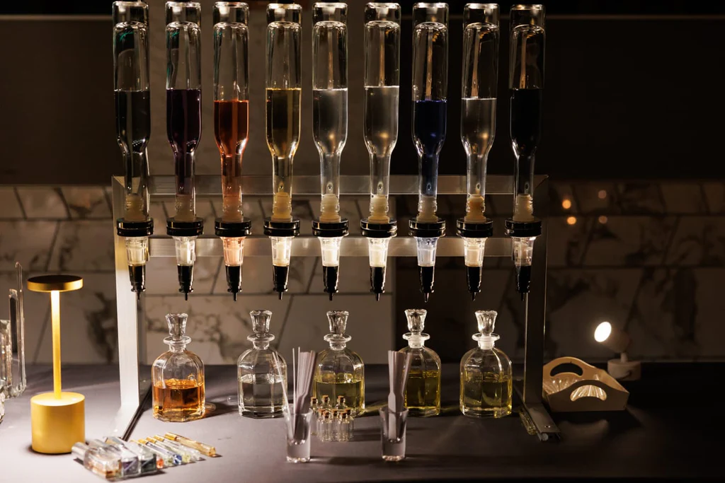 Elegant glassware and bottles in a bar setting with warm lighting.