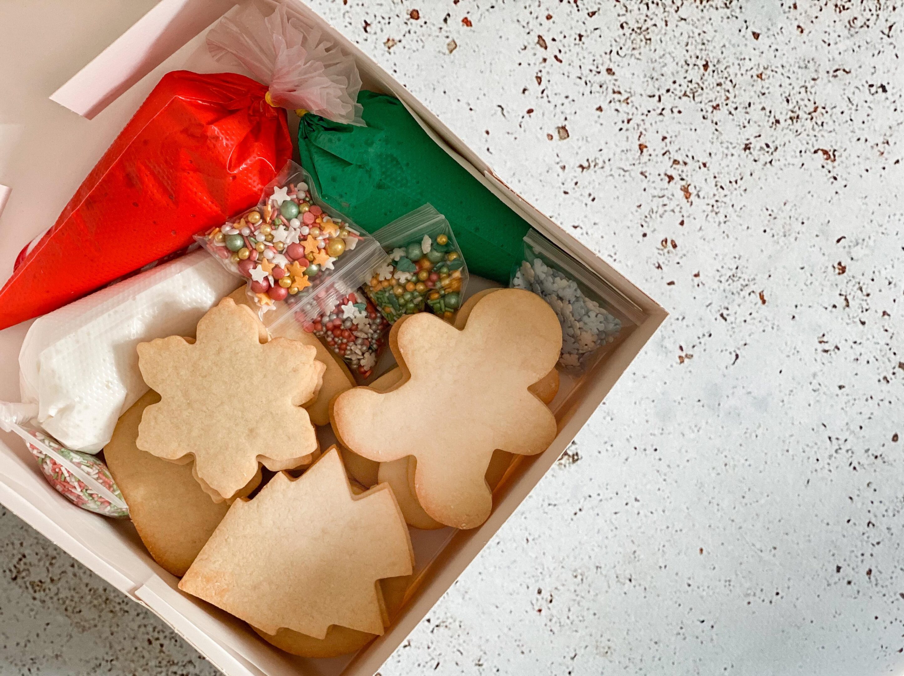 Box of gingerbread cookies with festive decorations.