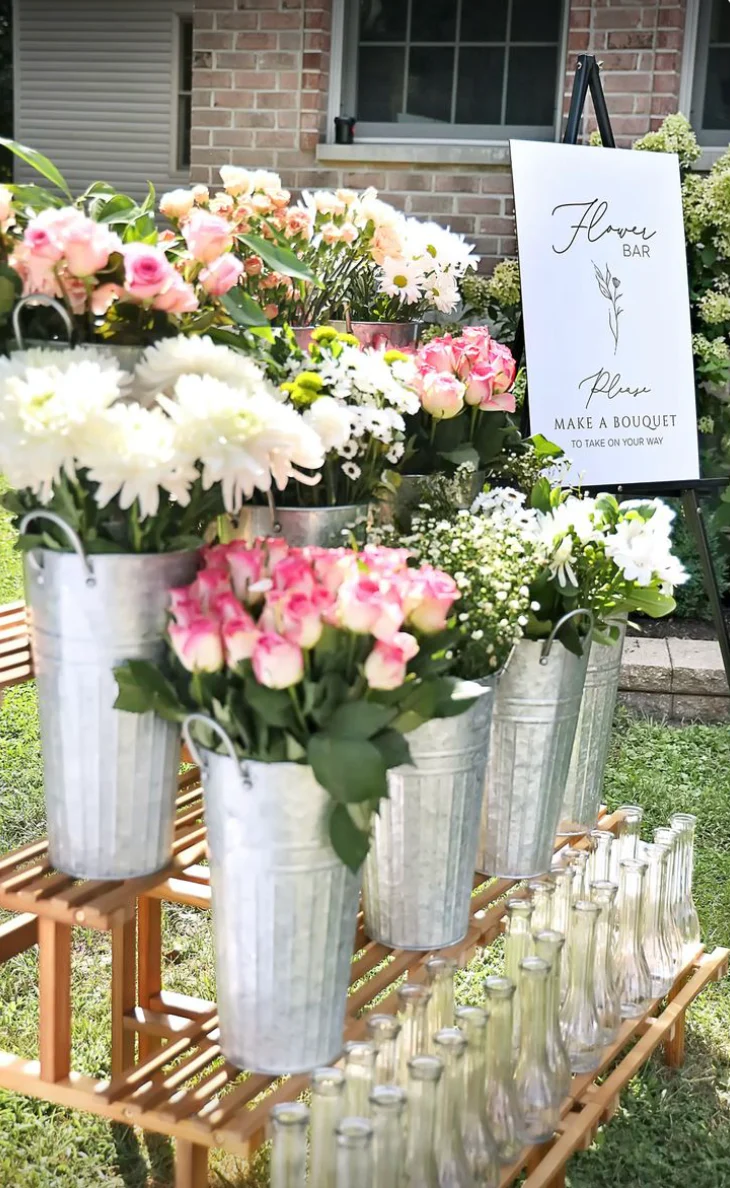 Buckets of fresh flowers arranged outdoors at a market stall.