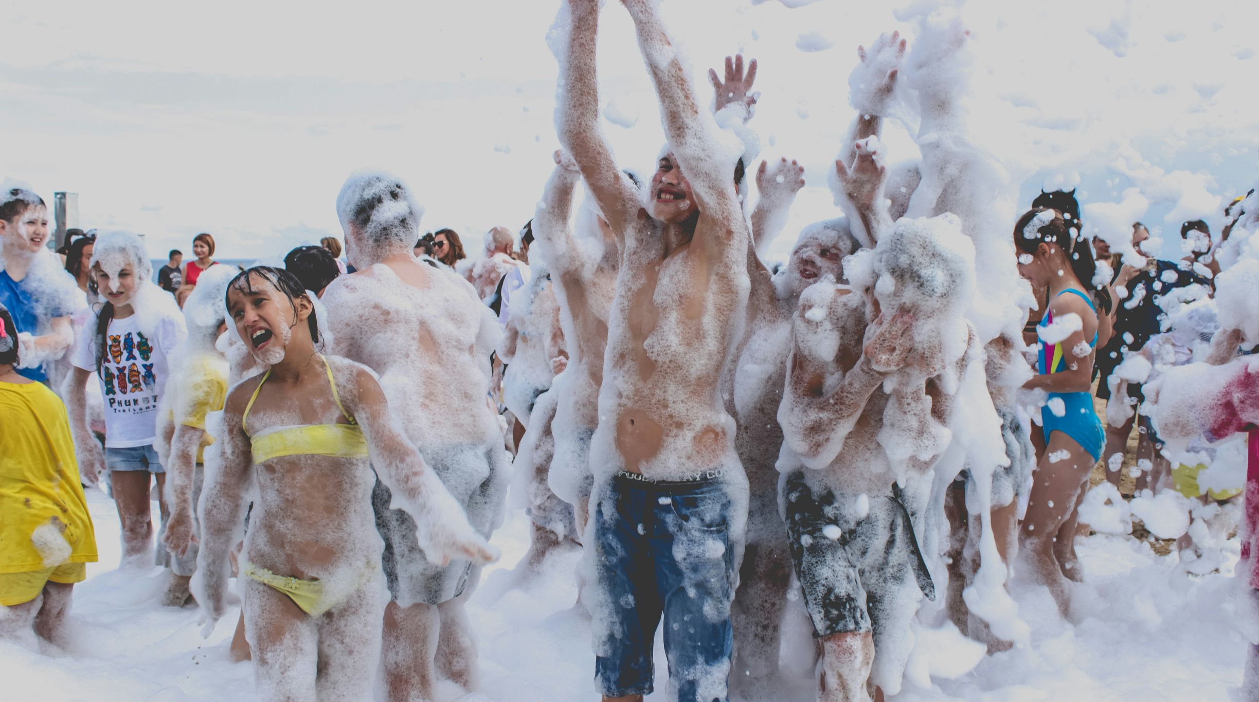 Group of people enjoying a foam party outdoors.