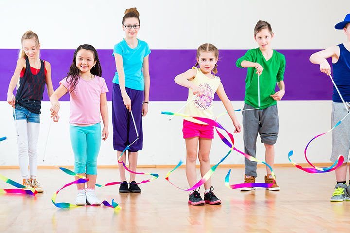 Children enjoying a hula hoop activity indoors.