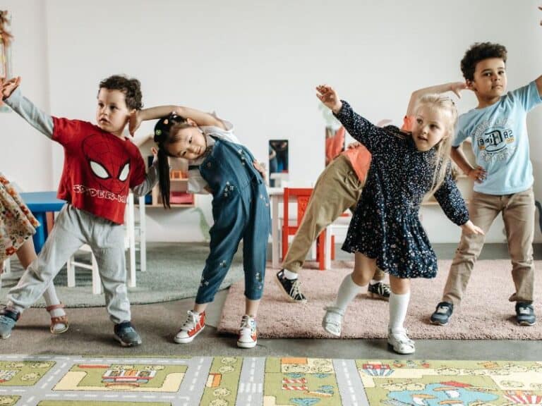 Preschool children stretching and dancing in classroom