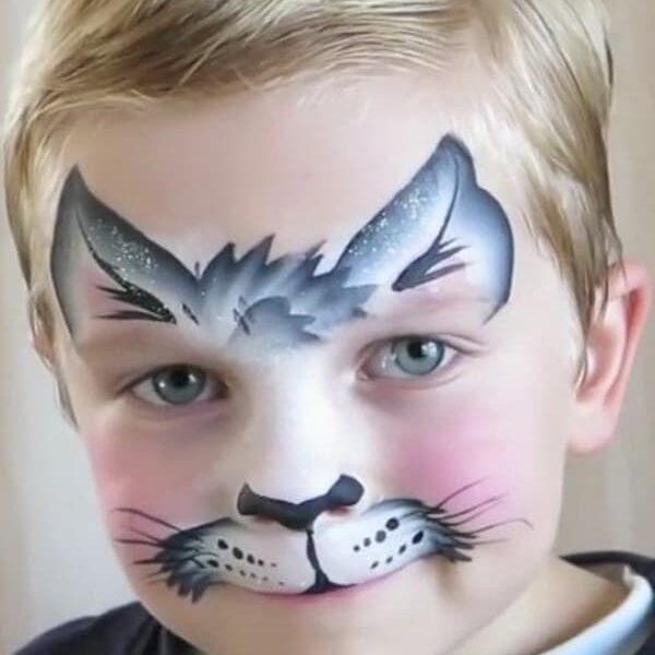Child with face paint resembling a cat, featuring whiskers and a nose.