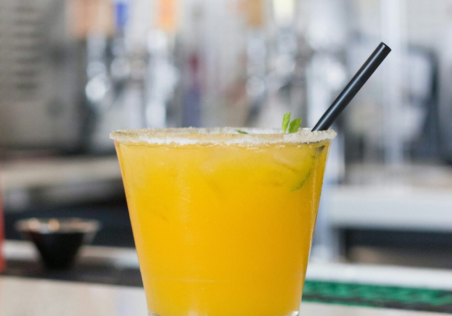 Orange cocktail with salted rim and straw