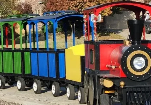 Colorful miniature train parked on street.